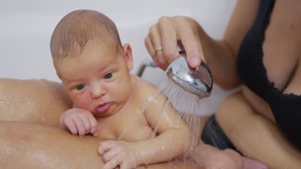 Funny newborn baby during bathing with mother. - Materiaali, video
