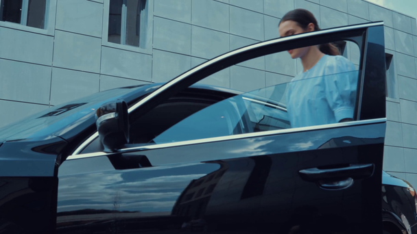 attraktive Frau steigt in schwarzes Auto auf Fahrersitz  - Filmmaterial, Video