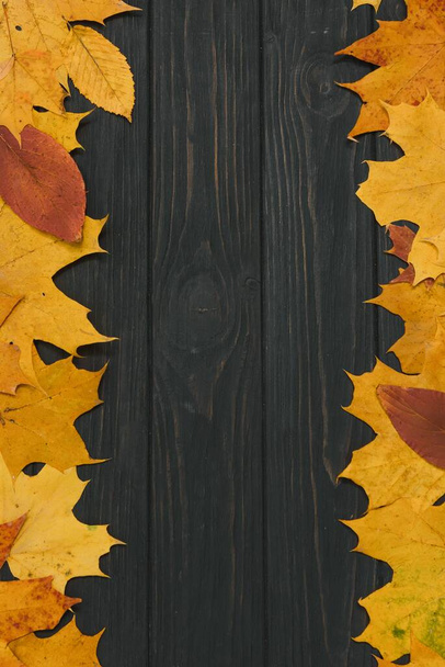 autumn leaf on wood black background (top view) orange leaf on old grunge wood deck, copy place for inscription, top view, tablet for text, - 写真・画像