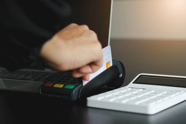 Dükkanda ürün satmak için kredi kartı okutma makinesi kullanan bir kadın. Kredi kartıyla harcama kavramı. - Fotoğraf, Görsel
