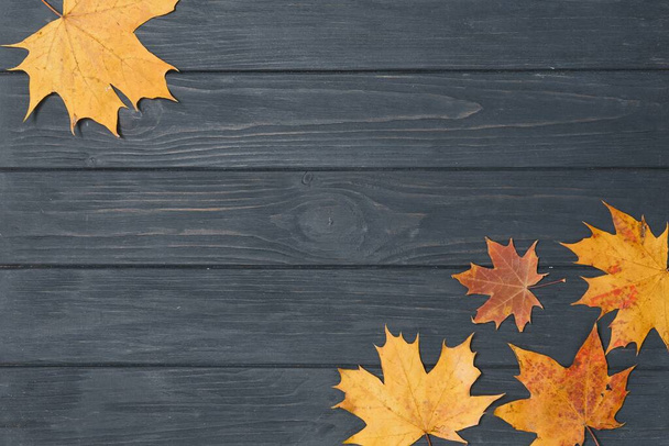 autumn leaf on wood black background (top view) orange leaf on old grunge wood deck, copy place for inscription, top view, tablet for text, - Foto, Imagen