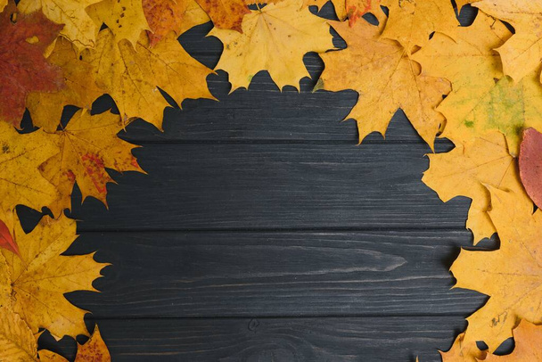 autumn leaf on wood black background (top view) orange leaf on old grunge wood deck, copy place for inscription, top view, tablet for text, - 写真・画像