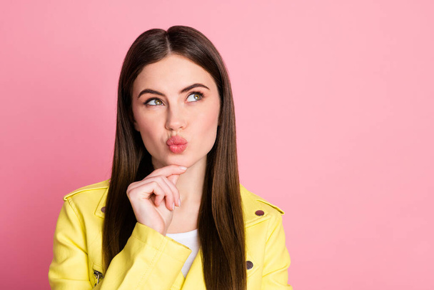 Closeup photo of pretty clever lady long perfect hairdo hold arm chin look up empty space pouted lips send kisses wear trend yellow leather jacket isolated pastel pink color background - Foto, afbeelding