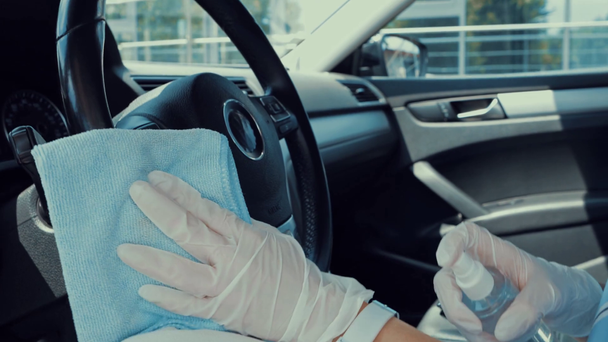 vista recortada de la mujer desinfectando el volante con desinfectante
 - Imágenes, Vídeo