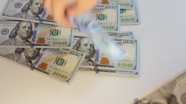 Egy csomó készpénz 100 dolláros bankjegyekben, fehér alapon számolva a pénzt. - Felvétel, videó