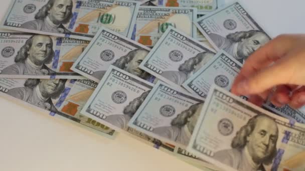 un sacco di contanti in banconote da 100 dollari, contando i soldi su uno sfondo bianco - Filmati, video