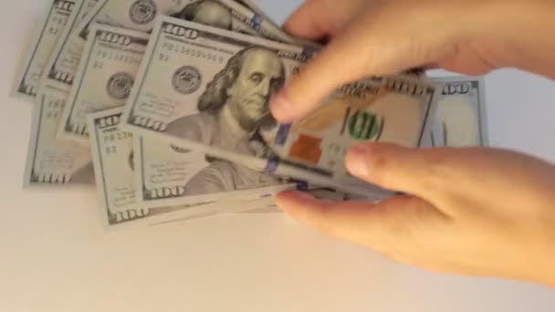 hodně peněz ve stodolarových bankovkách, počítání peněz na bílém pozadí - Záběry, video
