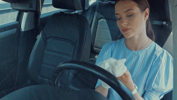 attractive woman putting on latex gloves while sitting on drivers seat - Footage, Video