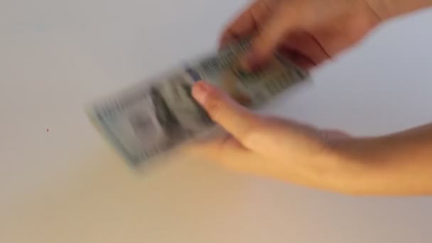 un sacco di contanti in banconote da 100 dollari, contando i soldi su uno sfondo bianco - Filmati, video