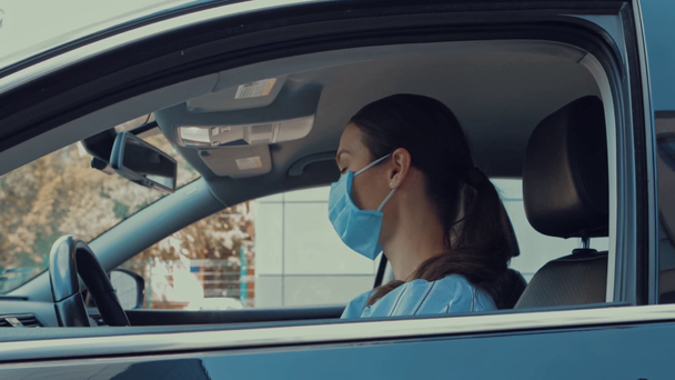 giovane donna salire in auto e togliersi la maschera medica - Filmati, video