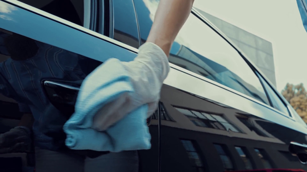 przycięty widok kobiety dezynfekującej klamkę i wsiadającej do samochodu   - Materiał filmowy, wideo