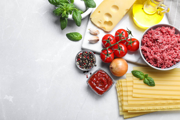 Fresh lasagna ingredients on light grey marble table, flat lay. Space for text - Fotoğraf, Görsel