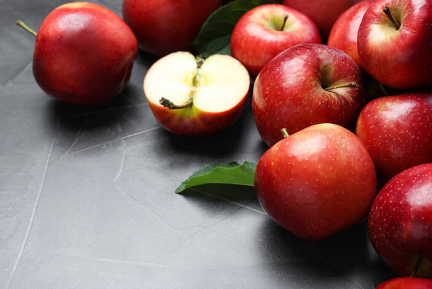 Ripe juicy red apples on grey table, closeup - Fotó, kép
