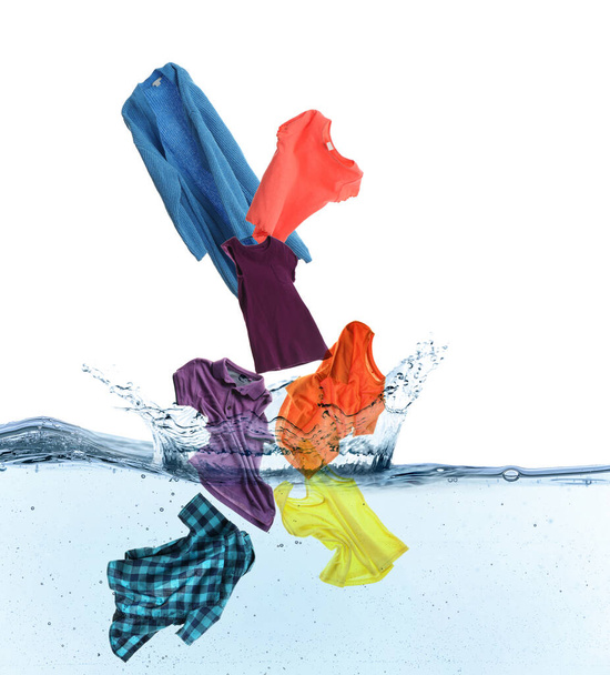 Different clothes falling into water against white background - Foto, Imagen