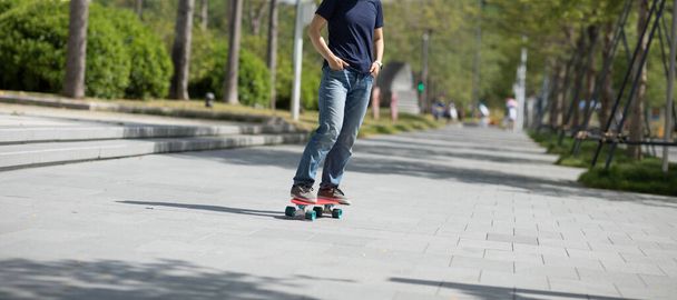 Азійська жінка - скейтбордист у сучасному місті. - Фото, зображення