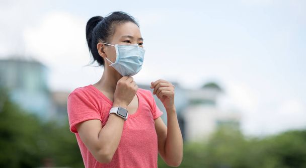 Asian woman wearing face mask  in city - 写真・画像
