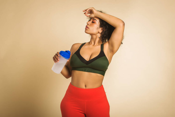 Pretty oversize woman wearing sportswear posing in studio - Beautiful girl accepting body imperfection, beauty shots in studio - Concepts about body acceptance, body positivity and diversity - Foto, Imagen