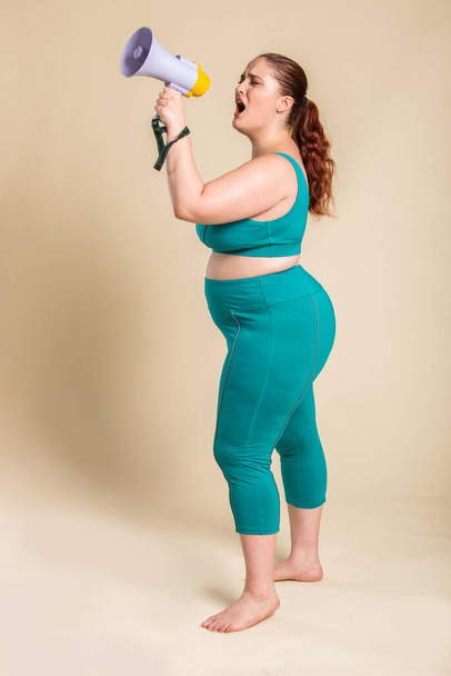 Pretty oversize woman wearing sportswear posing in studio - Beautiful girl accepting body imperfection, beauty shots in studio - Concepts about body acceptance, body positivity and diversity - Foto, Imagem