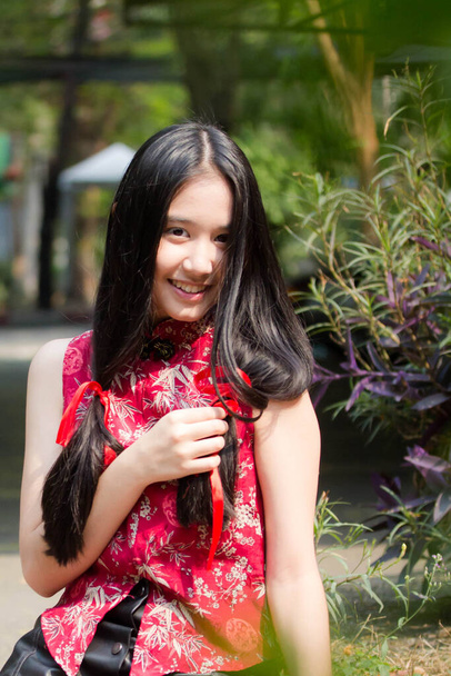 Portret tajskiej nastolatki piękna dziewczyna w chińskiej sukience, relaks i uśmiech. - Zdjęcie, obraz