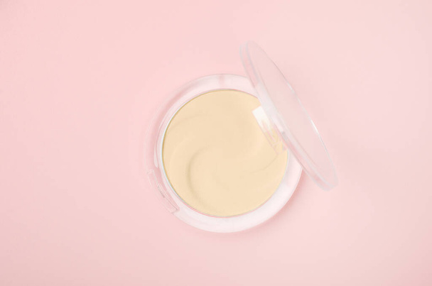 Face powder in round case top view. Fashion cosmetic, makeup product on pink background. Open eyeshadow, compact foundation cream. Facial concealer powder, cheek blush. Beauty accessory - Fotoğraf, Görsel