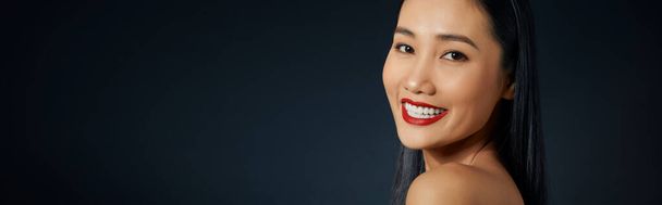 hermosa joven asiático mujer con largo cabello en oscuro gris aislado fondo
 - Foto, Imagen
