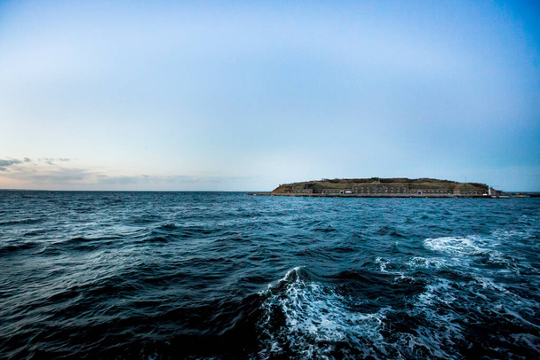 Agua azul, ondulada y una isla en el océano - Foto, imagen