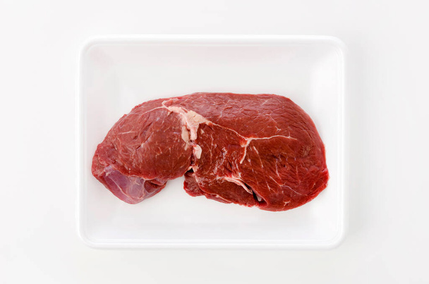 round steak on a foam tray on white background. - Foto, immagini