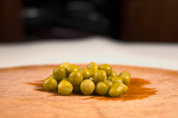 新鮮なエンドウ豆と小さな丸い木製のボード - 写真・画像