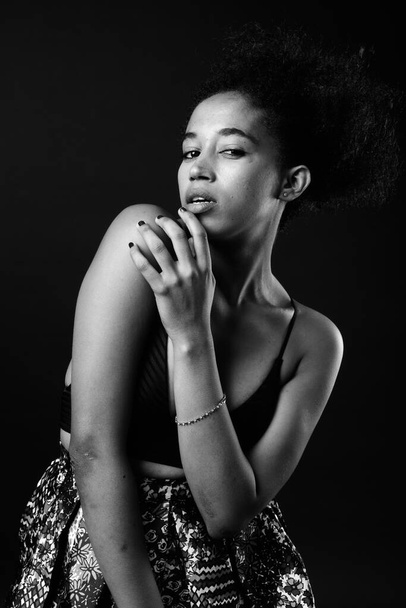 Studioaufnahme einer jungen schönen Afrikanerin mit Afro-Haaren in Schwarz-Weiß - Foto, Bild
