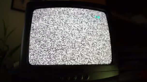 Старый ретро-телевизор, работающий в домашней комнате по ночам, винтажный телевизор со статическим шумом. Изменение телевизионных каналов на старом телевизионном устройстве, черно-белый глюк эффекты на экране. Изолированное ретро-телевидение в темной комнате - Кадры, видео