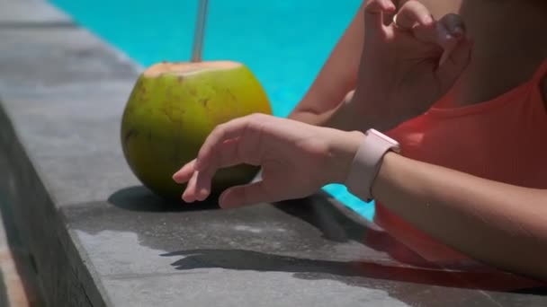 vrouwelijke toerist controleert smartwatch in zwembad - Video