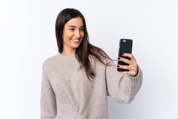 Mladá brunetka žena přes izolované bílé pozadí dělat selfie - Fotografie, Obrázek