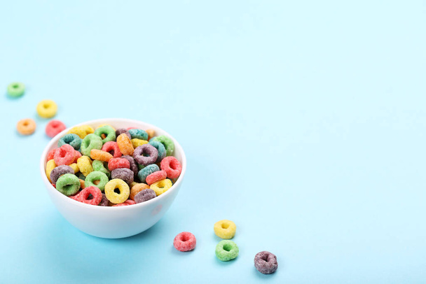 Colorful corn rings in bowl on blue background - Foto, immagini