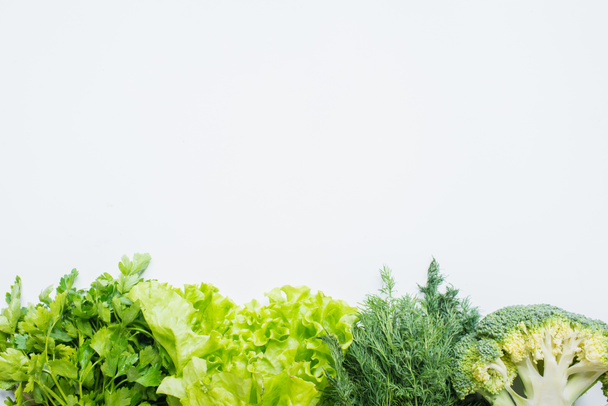 граница свежей зеленой петрушки, укропа, брокколи и салата изолированы на белом - Фото, изображение