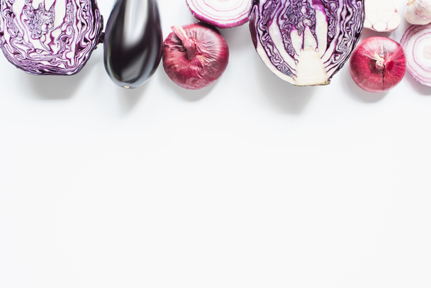 border of red onion, red cabbage, eggplant and garlic on white background - Photo, Image