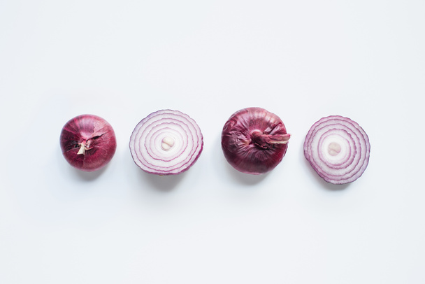 top view of cut and whole red onion on white background - Zdjęcie, obraz