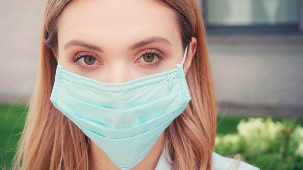 Joven estudiante de máscara médica mirando a la cámara en la calle urbana
  - Imágenes, Vídeo