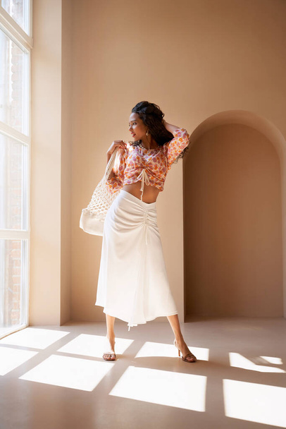 Mulatto female model posing near window indoors. - Foto, imagen