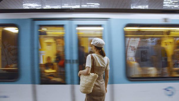 Jonge vrouw wacht op een trein op het station in de metro in Parijs - Foto, afbeelding