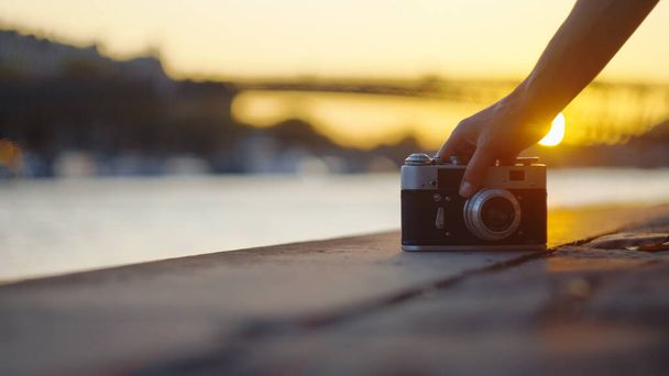 日没時にレトロなカメラを持つ若い写真家,クローズアップ - 写真・画像