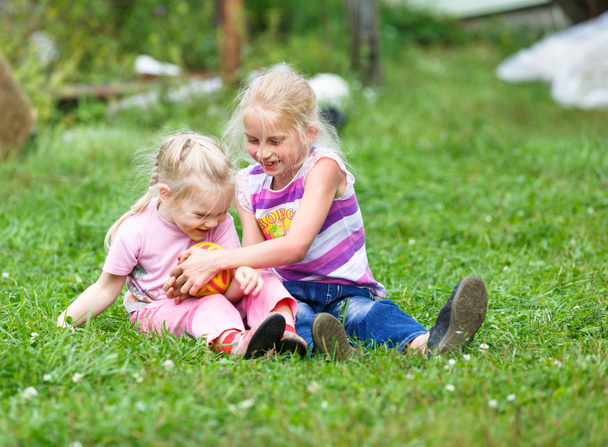 Dos chicas jugando en la hierba verde
 - Foto, imagen
