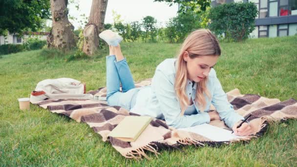 Time lapse of student reading book and writing in notebook in park - Filmati, video