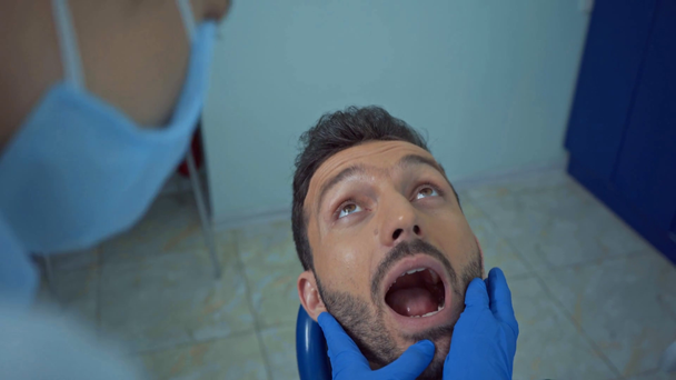 Selective focus of dentist examining patient teeth in clinic  - Πλάνα, βίντεο
