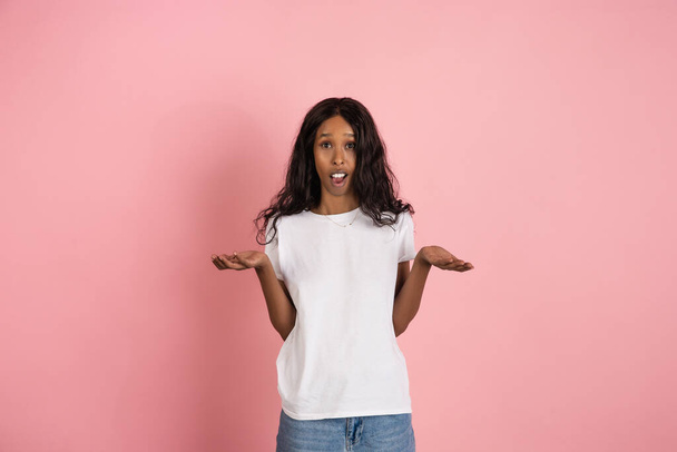 Cheerful african-american young woman isolated on pink background, emotional and expressive - Photo, Image