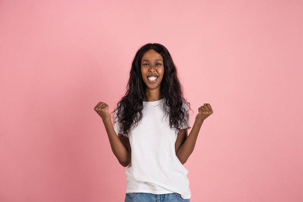 Cheerful african-american young woman isolated on pink background, emotional and expressive - Foto, immagini