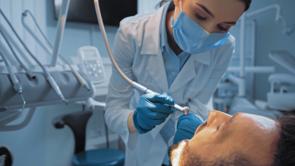 Стоматолог, работающий с пациентом на стоматологическом стуле в клинике - Кадры, видео