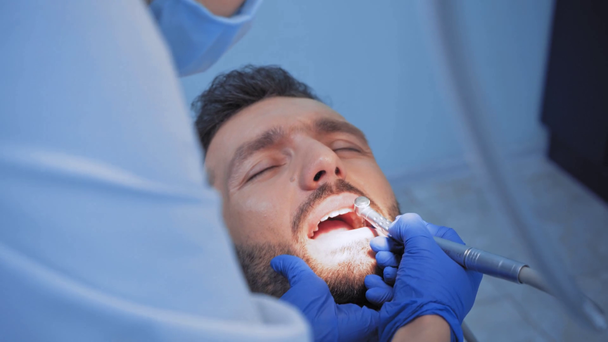 Επιλεκτική εστίαση του οδοντίατρου που εργάζεται με το αίσθημα πόνου του ασθενούς στην κλινική - Πλάνα, βίντεο