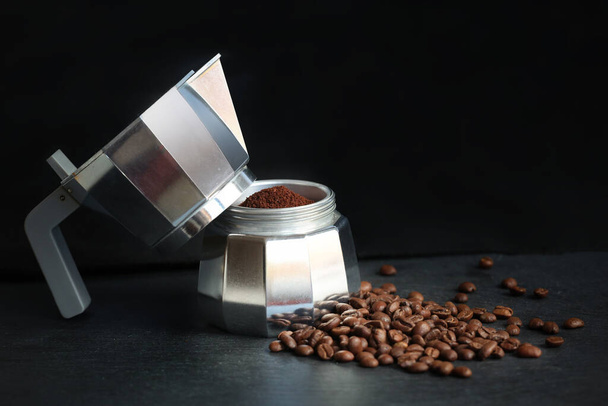 Kávé egy fazékban kávébabbal és őrölt kávéval homályos sötét háttérrel. Friss, hagyományos olasz eszpresszó kávé készítése. - Fotó, kép