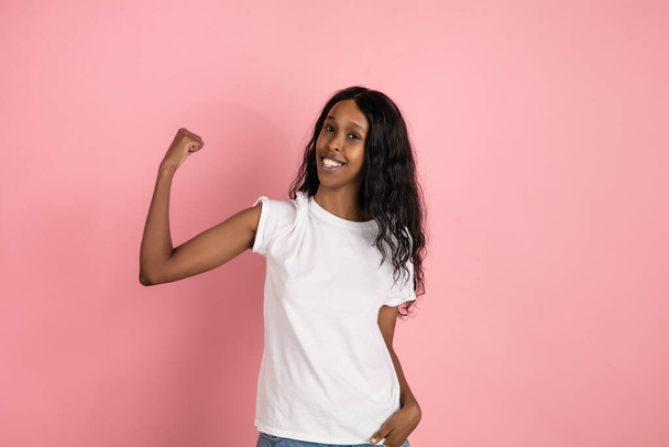 Cheerful african-american young woman isolated on pink background, emotional and expressive - Foto, immagini