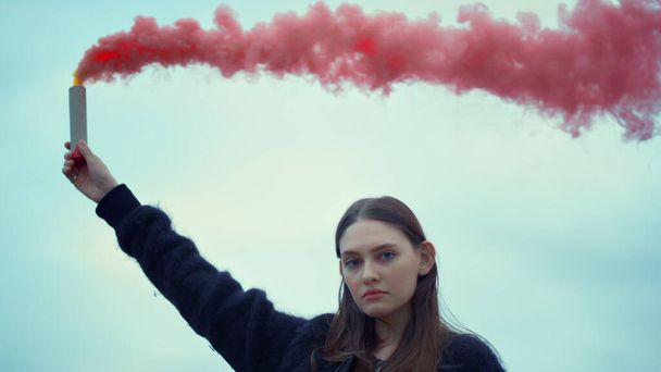 Chica sosteniendo una bomba de humo en la mano en la protesta callejera. Mujer usando granada de humo
 - Foto, Imagen